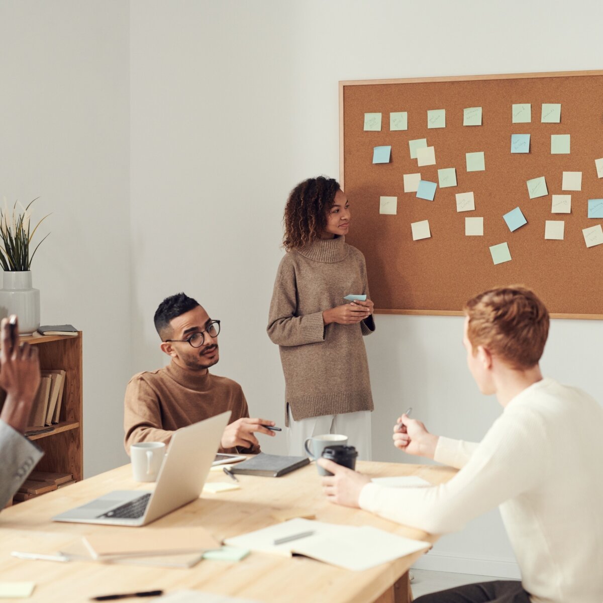 Team around table and pinboard with post it notes