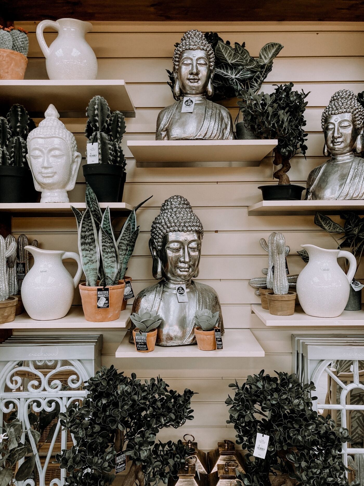 Store display mixing vases, statues, pitchers and plants in whites, greens, and silver