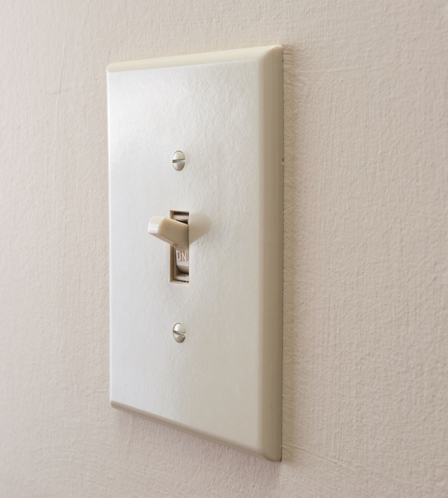 Light switch on wall turned to on position.