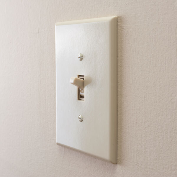 Light switch on wall turned to on position.
