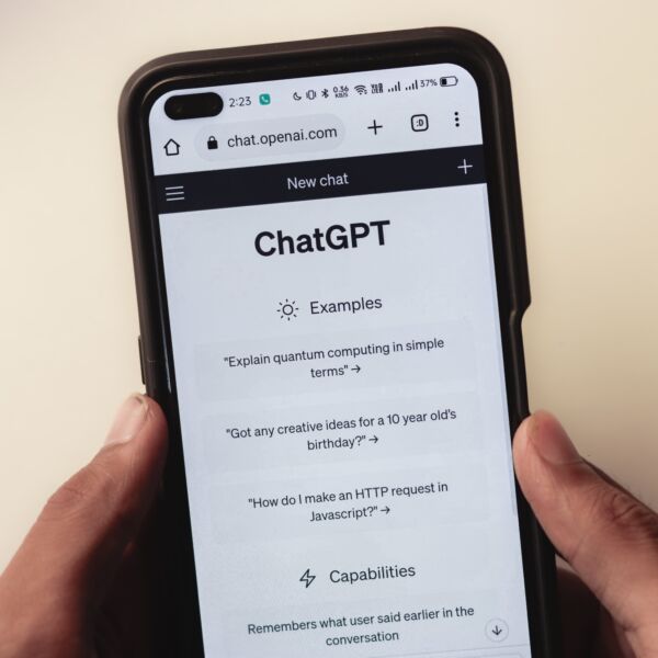 Hands holding a phone with ChatGPT on the screen.