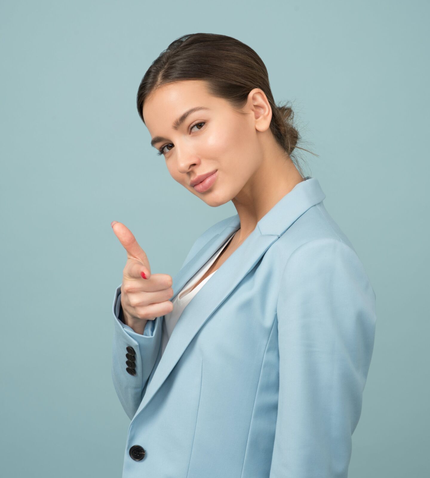Woman wearing blue shawl lapel suit jacket pointing at you and looking very confident